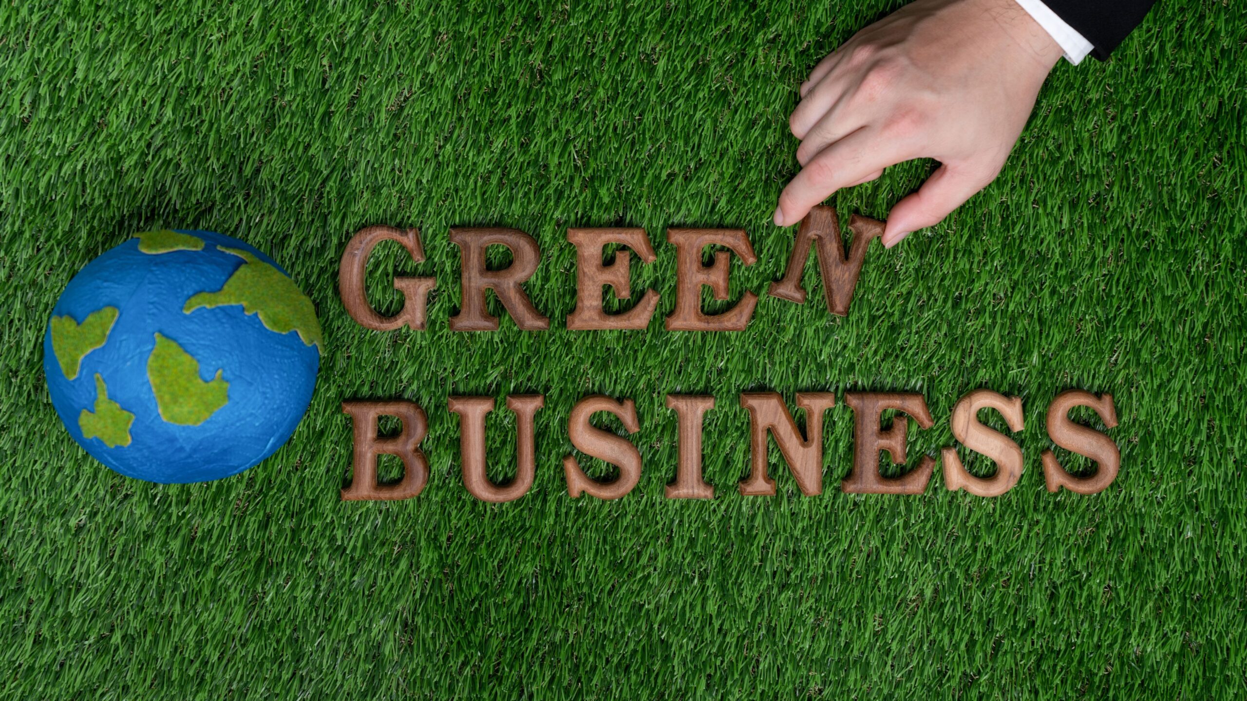Businessman’s hand arrange message in Green Business. Gyre
